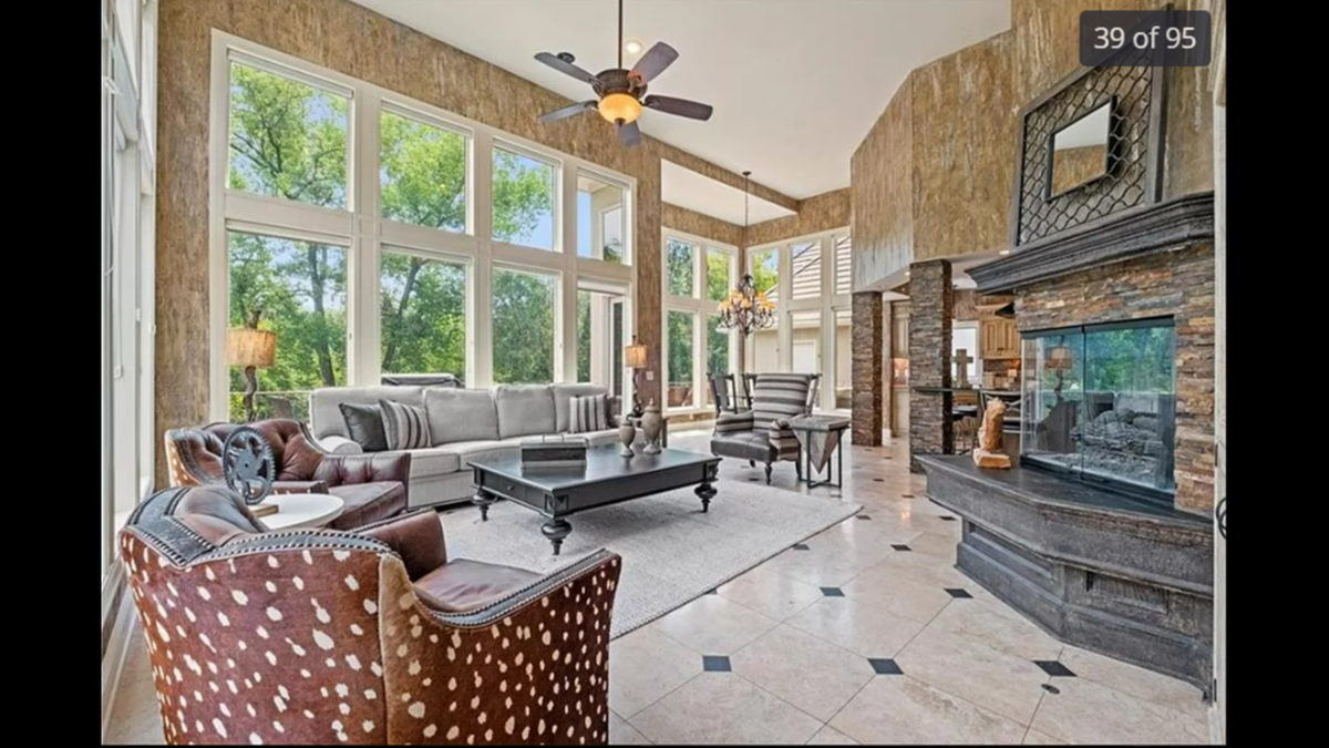 One of the living rooms inside 425 NE St. Andrews Circle in Lee’s Summit is next to one of four gas-powered fireplaces on the property.