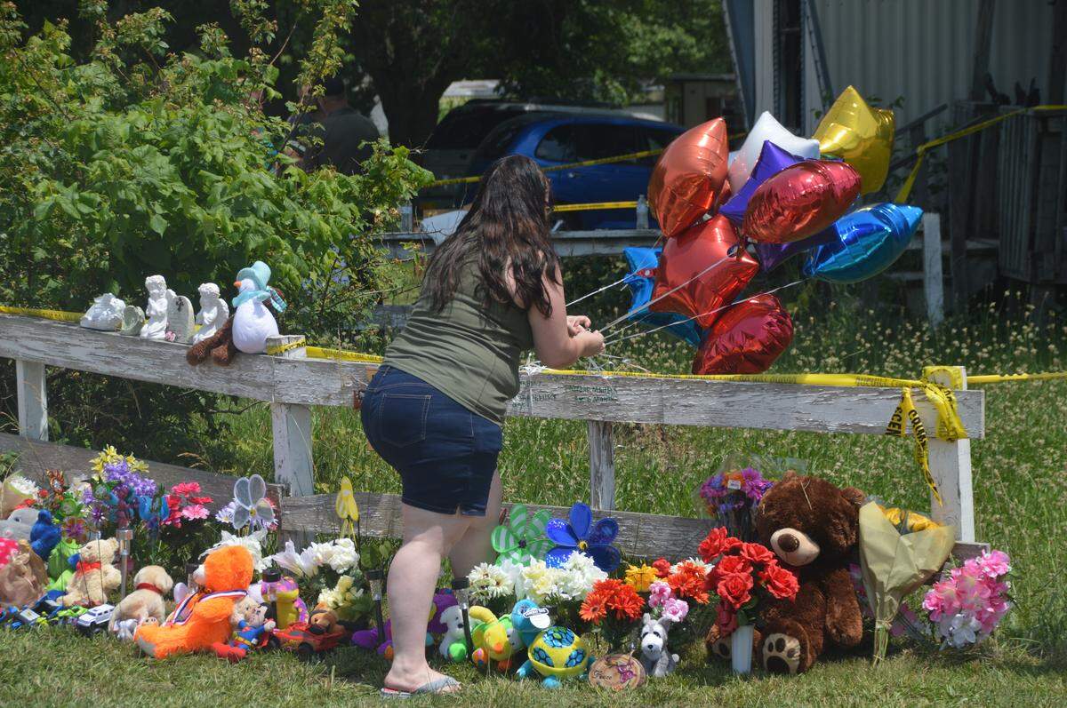 Community members started a memorial outside a home in Lebanon, Mo., where five children were killed and one adult was injured on Wednesday, June 6, 2018. Audrianna Middlesworth, mother to three of the children, visited the home Thursday.