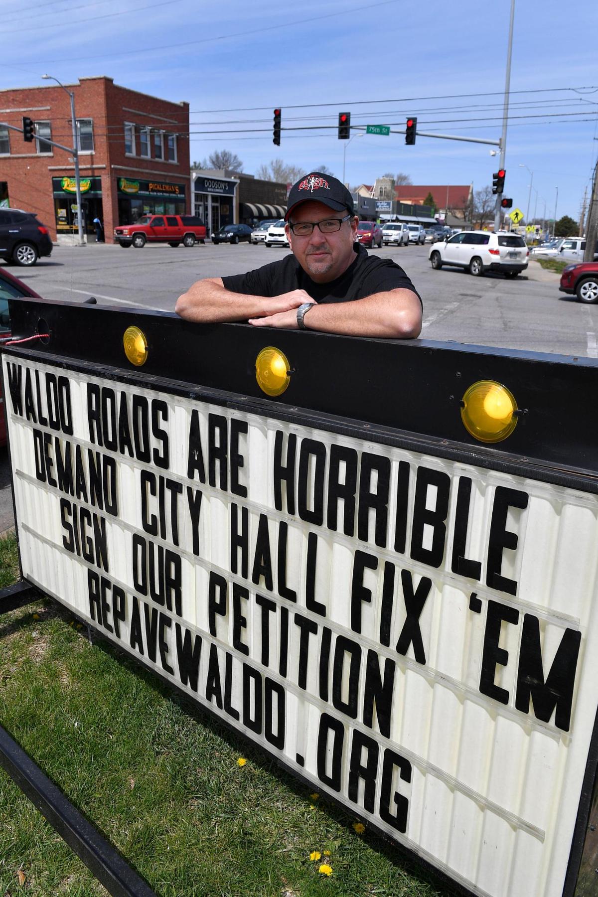 Frank Sereno parked himself and his mobile marquee at the intersection of 75th Street and Wornall Road in an effort to encourage passing motorists to sign his online petition. The petition demands that the city repair or resurface the deteriorated streets in the Waldo neighborhood in Kansas City.
