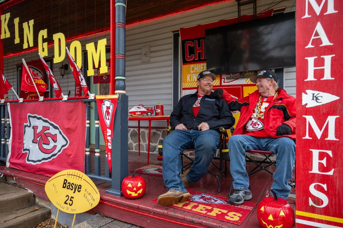 Dennis Basye, a dedicated Kansas City Chiefs super fan, and his son Travis sit together on the front porch of their Chiefs-themed decorated home on Sunday, Feb. 4, 2024, in Sedgwick, Kansas. Basye, who has been collecting Chiefs merchandise for five years, annually enhances his house display with new additions.