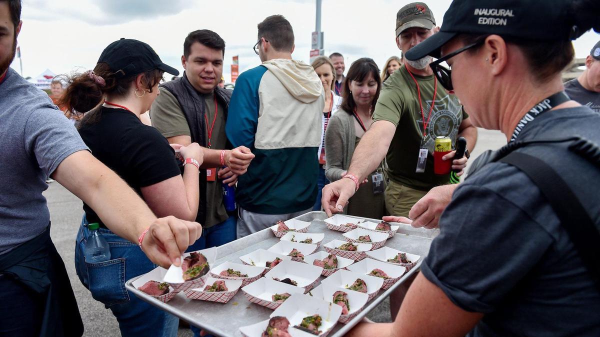 Katie Chavez, right, hands out samples of bison tenderloin with chimichurri sauce after a demonstration by Sterling Smith of Loot N Booty BBQ in Scottsdale, Arizona. The three-day Kansas City BBQ Festival in the parking lot of the GEHA Field at Arrowhead Stadium concluded Sunday, July 11, 2021.