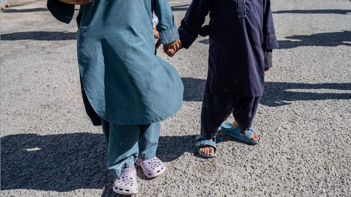 HOLLOMAN AIR FORCE BASE, NM - NOVEMBER 04: Afghan refugee children stand for a photograph in an Afghan refugee camp on November 4, 2021 in Holloman Air Force Base, New Mexico. The Department of Defense and US Department of Homeland Security’s initiative, Operation Allies Welcome, aims to support and house Afghan refugees as they transition into more permanent housing in the US. (Photo by Jon Cherry/Getty Images)