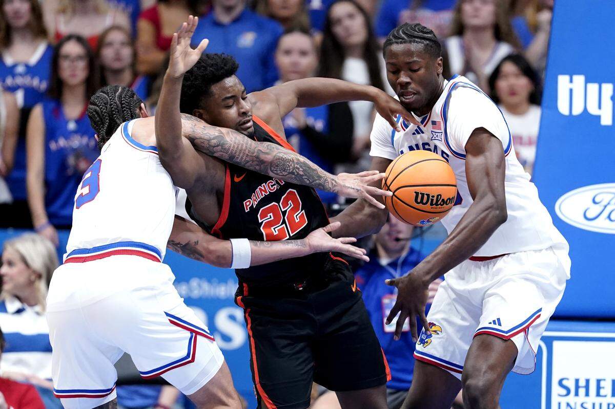 Dalen Davis #22 of the Princeton Tigers loses control of the ball against Tre White #3 and Flory Bidunga #40 of the Kansas Jayhawks in the first half at Allen Fieldhouse on November 15, 2025 in Lawrence, Kansas.