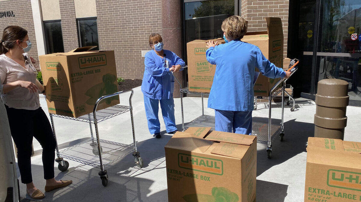 Workers at North Kansas City Hospital accept a delivery of meals from Mr. Bevis BBQ brought up from Olathe by Easy Peasy Moving Company April 21.