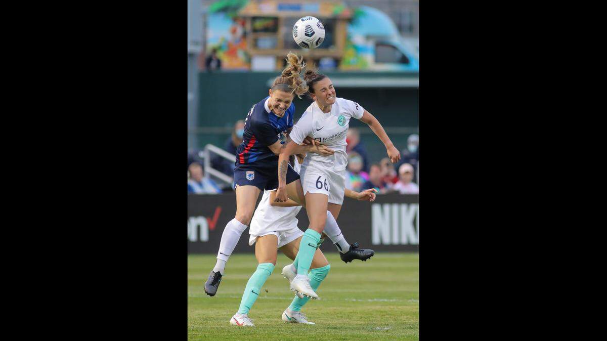 Chole Logarzo of the Kansas City National Women’s Soccer League team goes up for a header against Kristen McNabb of the OL Reign in a NWSL Challenge Cup match on May 3, 2021 at Legends Field in Kansas City, Kansas.