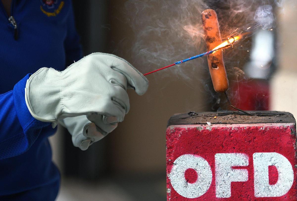 Michelle McLane, public education specialist for the Olathe Fire Department, used a sparkler on a hot dog to demonstrate how easily a person could suffer burns.