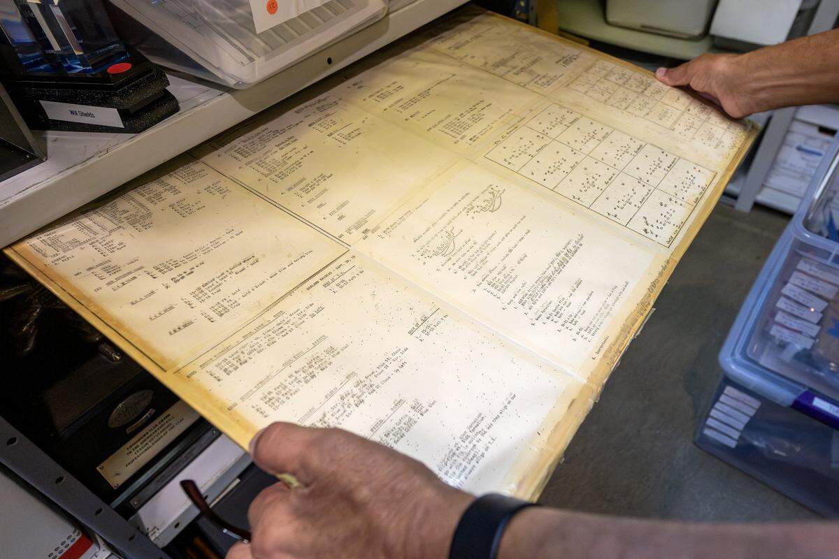 Kansas City Chiefs historian Mike Davidson shows a sheet of old play-calls that is stored in the Artifact Room inside the team’s underground storage facility in Kansas City.