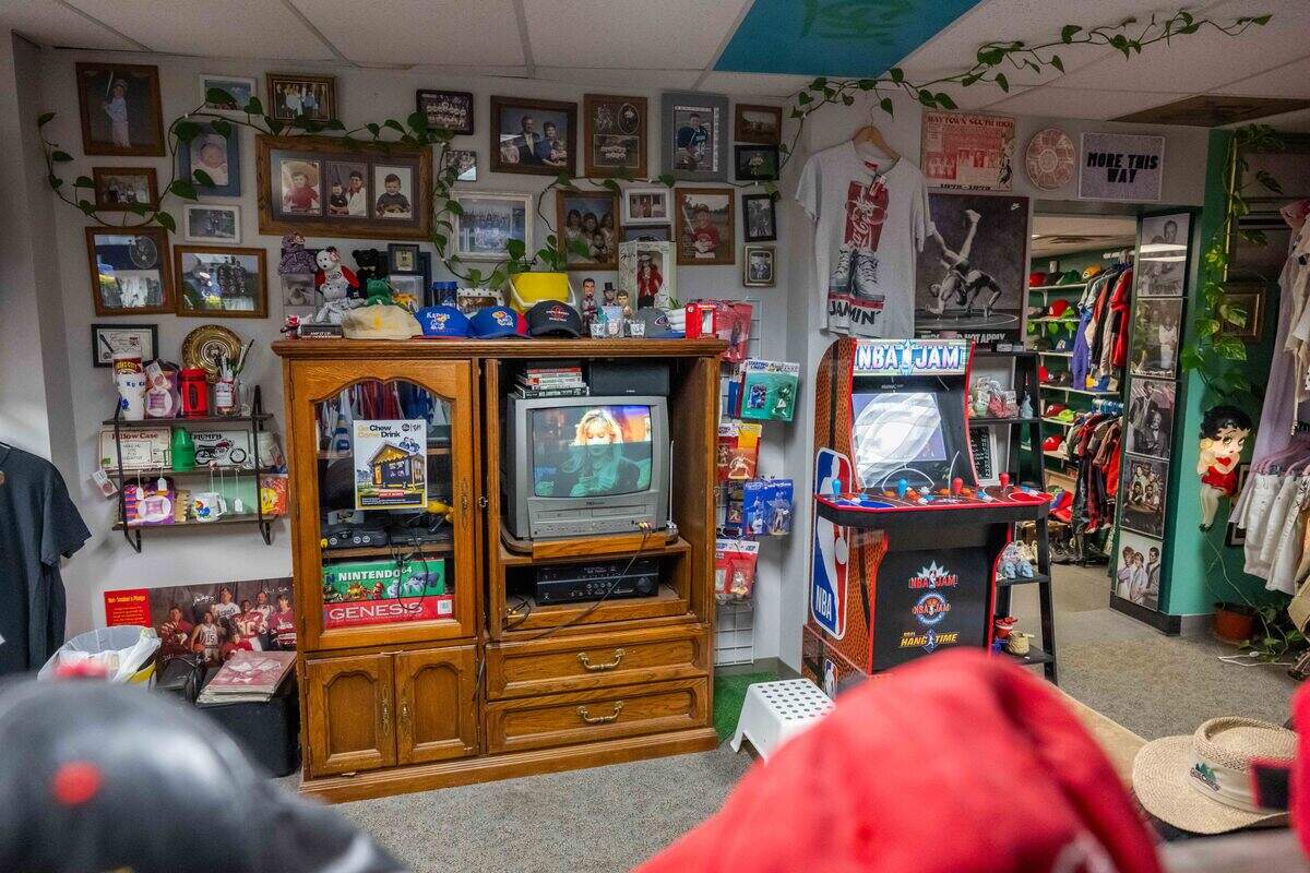 The ‘living room’ inside Gnarly Hussle, a vintage clothing store in Raytown, on Thursday, Nov. 20, 2025. The vibe of the shop is similar to a cool friend’s family room, down to the tube TV and family photos on the wall.