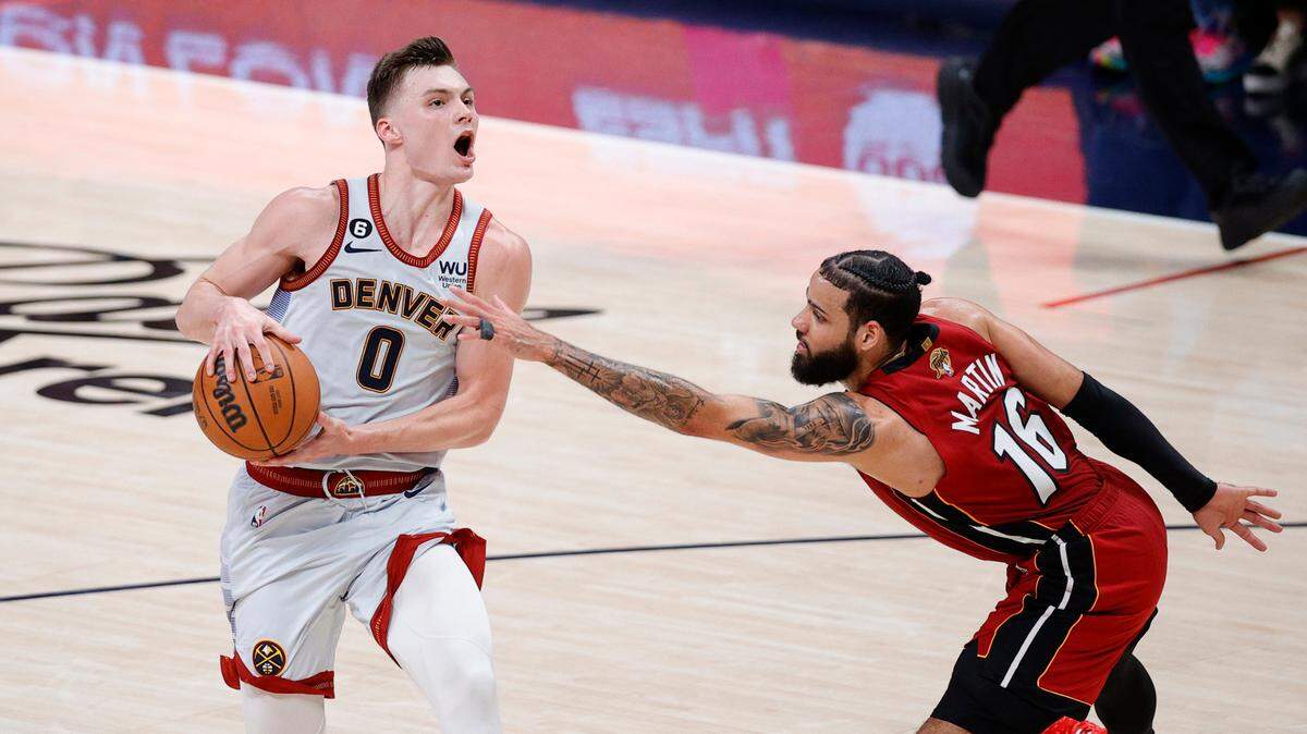 Denver Nuggets guard Christian Braun (0) drives against Miami Heat forward Caleb Martin (16) during the fourth quarter of Game 5 of the 2023 NBA Finals at Ball Arena on June 12, 2023.