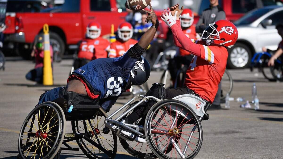 A player for the Kansas City Chiefs wheelchair football team tries to make a catch over a Birmingham (Alabama) Hammers defender during one of the Saturday afternoon games at the national tournament outside Arrowhead Stadium.