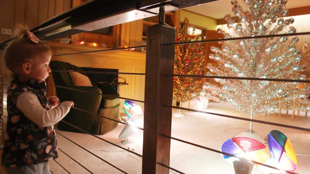 Two-year-old Anah Everding of Houston checked out the brightly lit color wheels projecting onto the aluminum trees at the Johnson County Museum’s all-electric house.