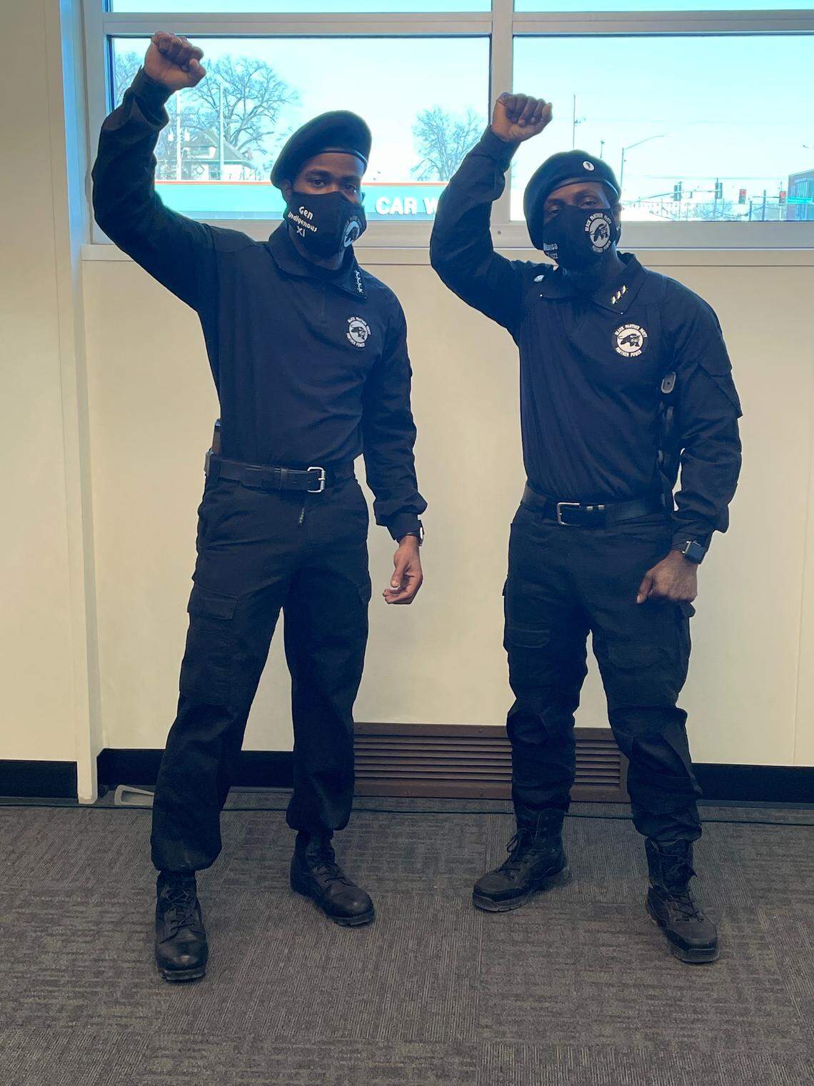 Two members of the Kansas City chapter of the Revolutionary Black Panther Party, dressed in their traditional all-black clothing and berets, held up the Black Power fist.