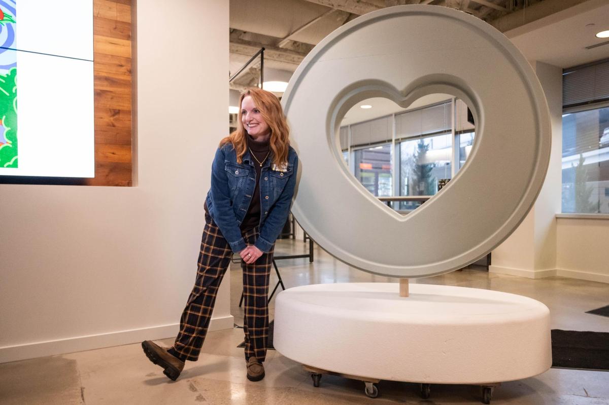Jaime Simpson poses next to the new Parade of Hearts redesign on Tuesday, Mar. 4, 2025 in Kansas City. The hearts will be placed in seven counties across the Kansas City region.