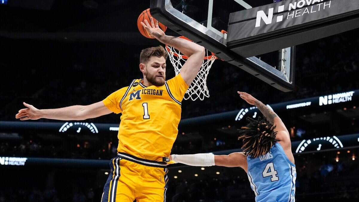 Michigan center Hunter Dickinson (1) blocks a shot by UNC guard R.J. Davis (4) during the first half at the Jumpman Classic at the Spectrum Center in Charlotte, North Carolina, on Dec. 21, 2022.