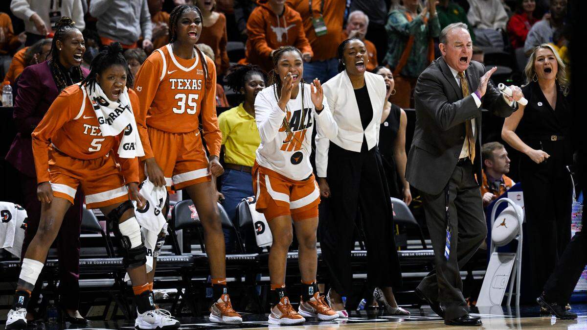 Texas head coach Vic Schaefer, wearing suit at right, and his bench celebrate a play against Baylor during the first half of an NCAA college basketball championship game in the Big 12 Conference tournament in Kansas City, Mo., Sunday, March 13, 2022. (AP Photo/Reed Hoffmann)