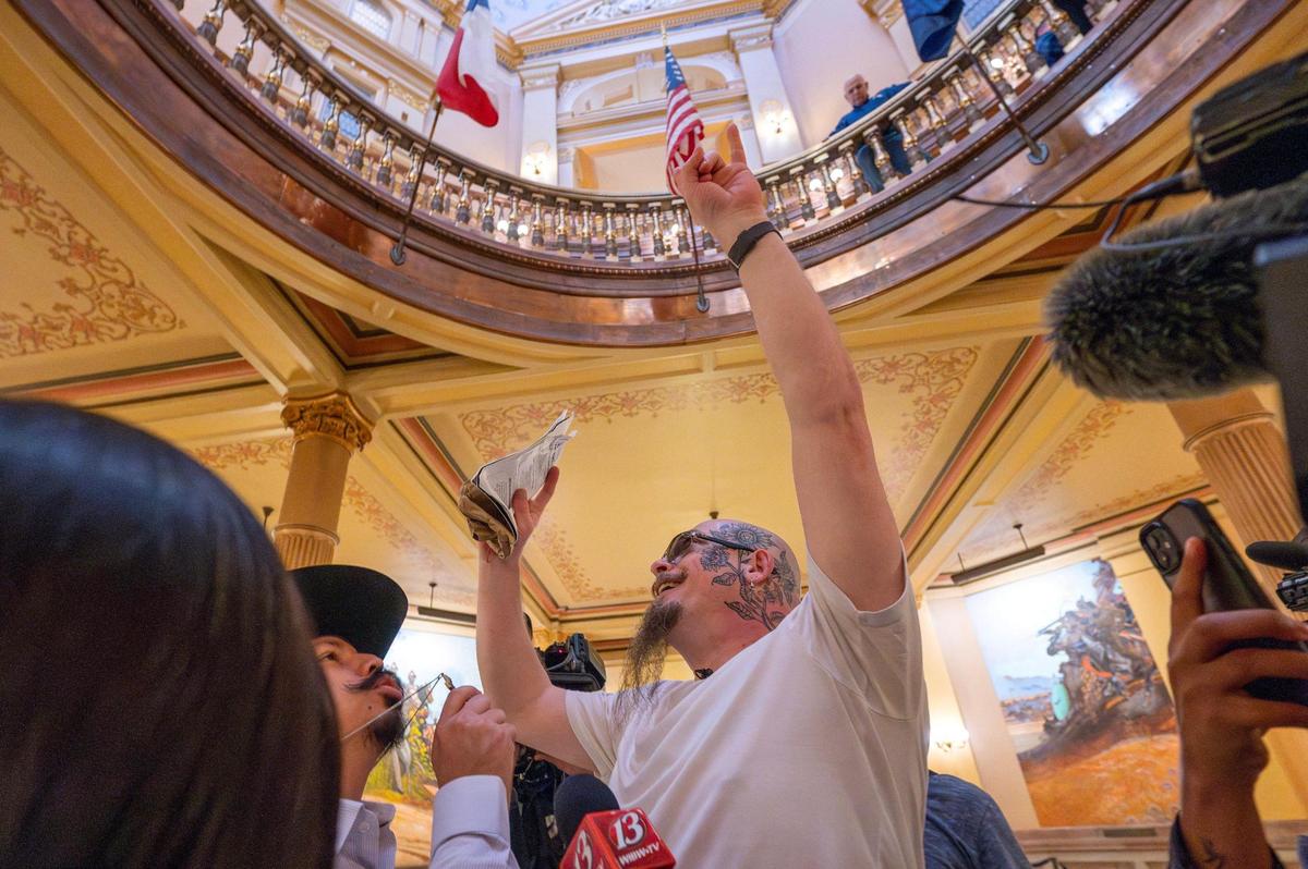 Satanic Grotto leader Michael Stewart recites a passage from a black book during a Black Mass ritual inside the rotunda of the Kansas State Capitol on Friday, March 28, 2025, in Topeka.