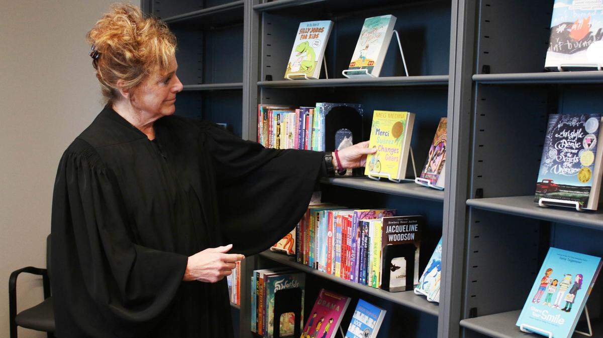 Judge Kathleen Sloan looks at the Courtroom Assisted Reading Encouragement display near her courtroom at the Johnson County Courthouse in Olathe.