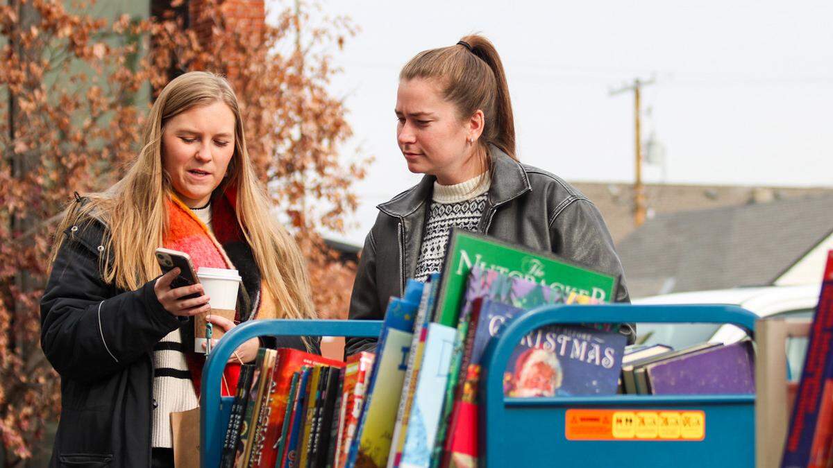 Customers stand outside near book racks at Monstera’s Books, 7930 Floyd St. in Overland Park on Dec. 6, 2025.