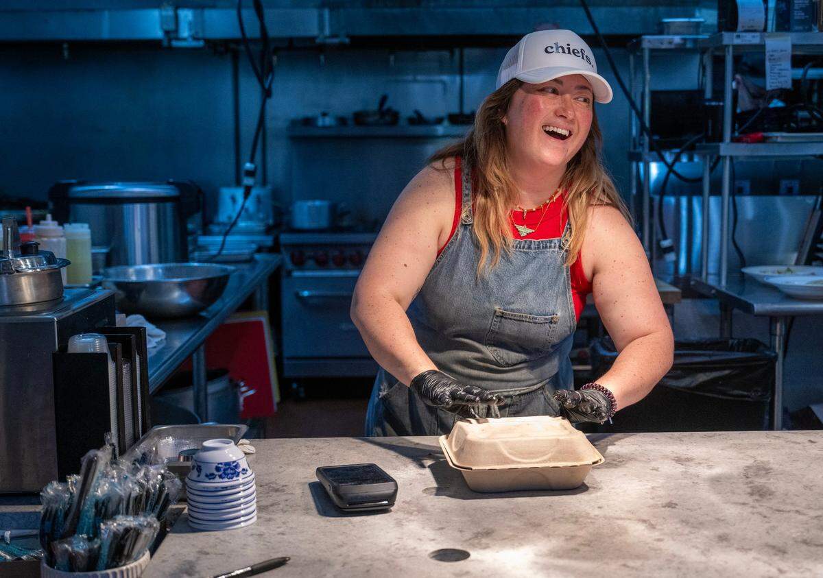 Chef Ashley Bare laughs as she boxes up a to-go order in the kitchen on Friday, Sept. 20, 2024, at Hemma Hemma, 7122 Wornall Rd, Kansas City. 