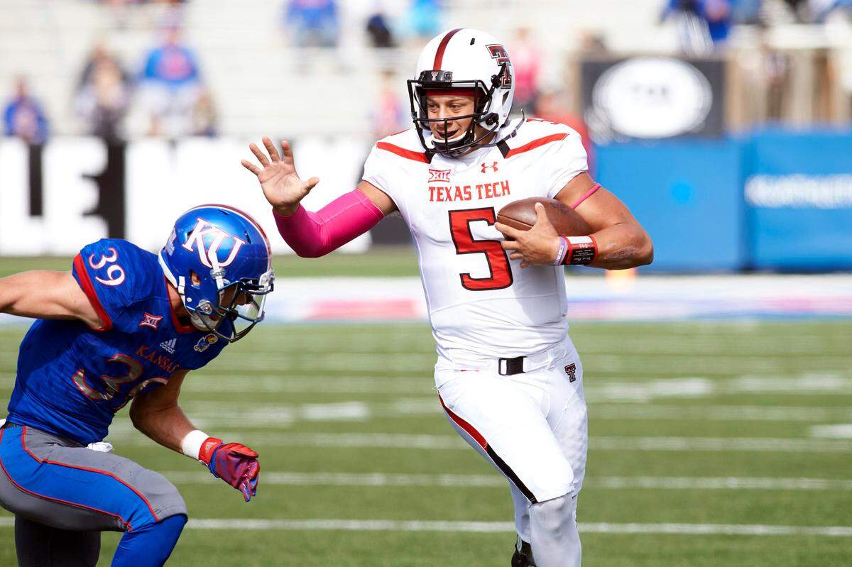 Texas Tech quarterback Patrick Mahomes, right, scrambles during a game against KU at David Booth Kansas Memorial Stadium.