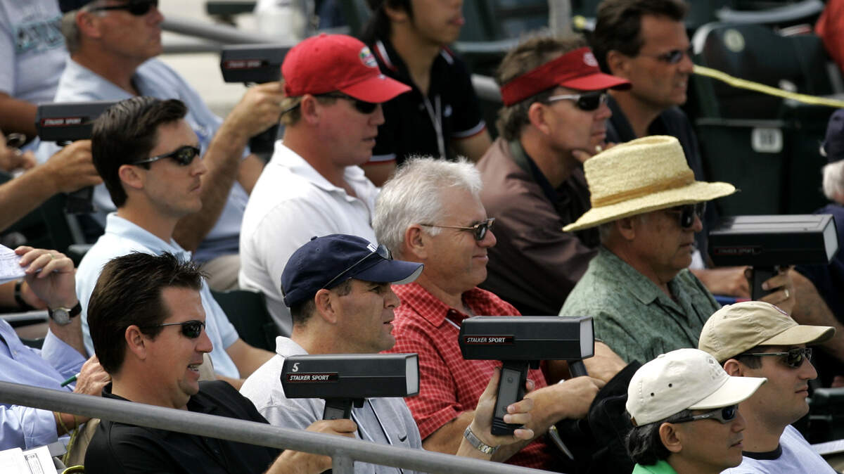 FILE - In this March 20, 2007, file photo, baseball scouts use radar guns to read the speed of a pitch during a spring training baseball game between the Florida Marlins and the Washington Nationals in Jupiter, Fla. Longtime baseball men who once hit the road ahead of their clubs to offer detailed insight of upcoming opponents are largely no longer as advance scouting for many teams has turned to technology: video and analytics. (AP Photo/Charlie Riedel, File)