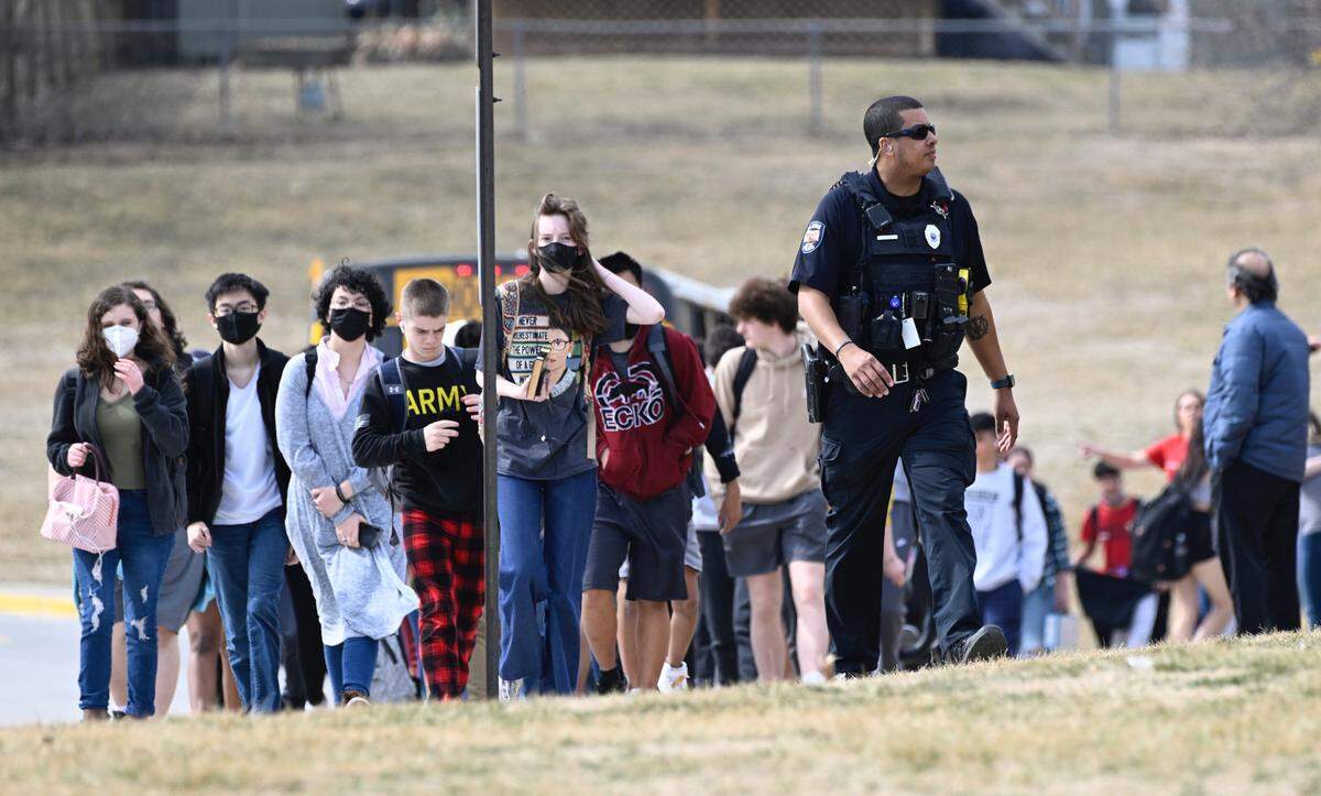 Students from Olathe East High school are led off buses to reunite with their parents Friday at Pioneer Trail Middle School in Olathe after a shooting at the high school.