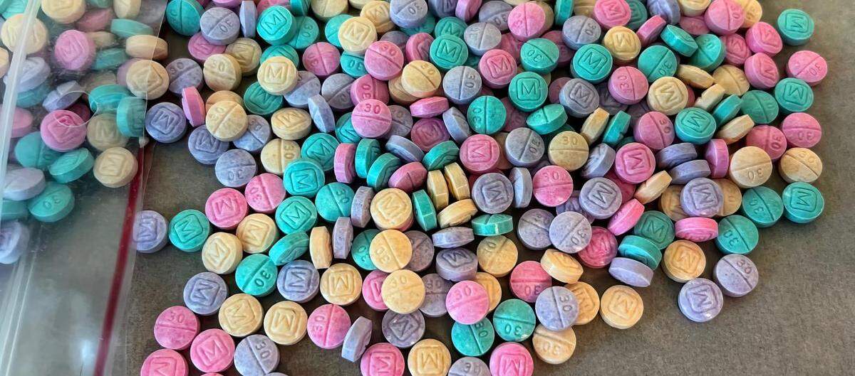 An image from the Drug Enforcement Administration shows multicolored counterfeit “M-30” pills designed to look like Oxycodone tablets. Counterfeit prescription drugs dyed in bright colors may contain dangerous levels of fentanyl, which has led to thousands of overdose deaths around the country.
