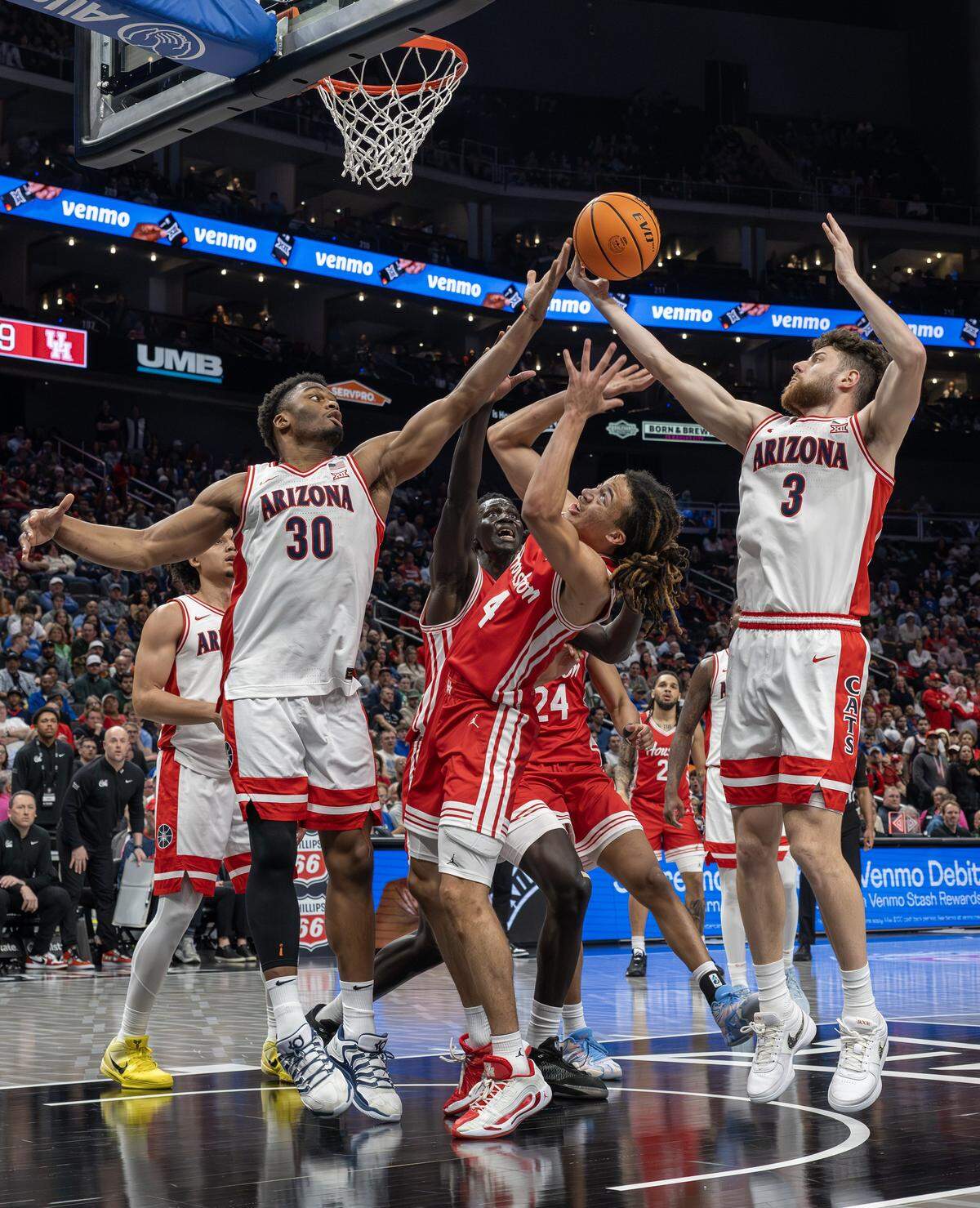 Arizona forward Tobe Awaka (30), Houston guard Kingston Flemings (4) and Arizona guard Anthony Dell'Orso (3) attempt to grab a rebound during the first half of the Big 12 Men's Basketball Tournament Championship game at T-Mobile Center on Saturday, March 14, 2026, in Kansas City.