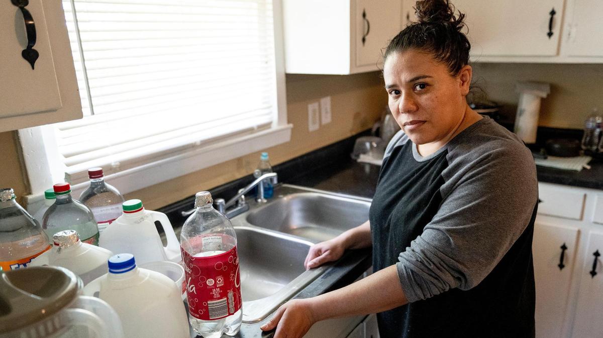 Jessica Martinez poses for a photo on Friday, May 26, 2023, in Kansas City. Due to an outstanding balance left by a previous tenant, KC Water shut off water to Martinez’s home in April. Since then, the family has had to get creative for their water needs including transporting trash cans full of water by car to their home and using bottled water to brush their teeth.
