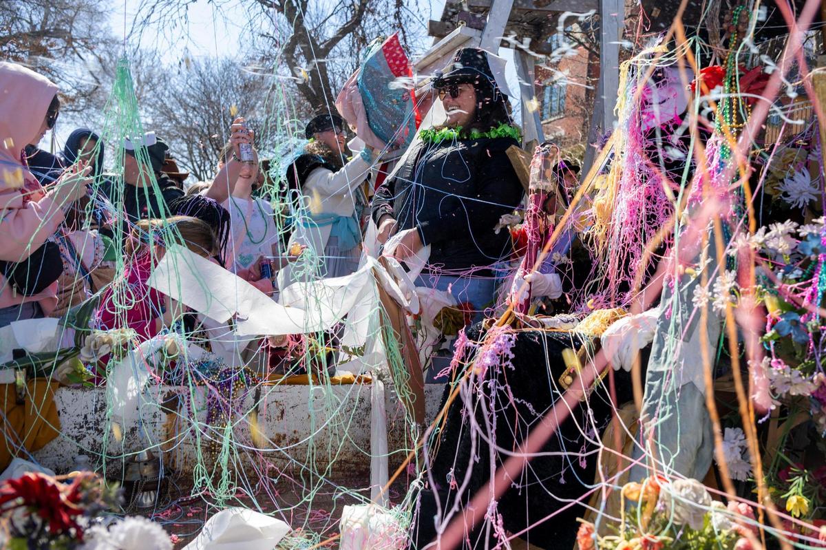 Children use silly string, toilet paper and confetti to cover Maximón, the patron saint of bad behavior, during the Krewe de Prank parade on Sunday, March 2, 2025, in Kansas City.