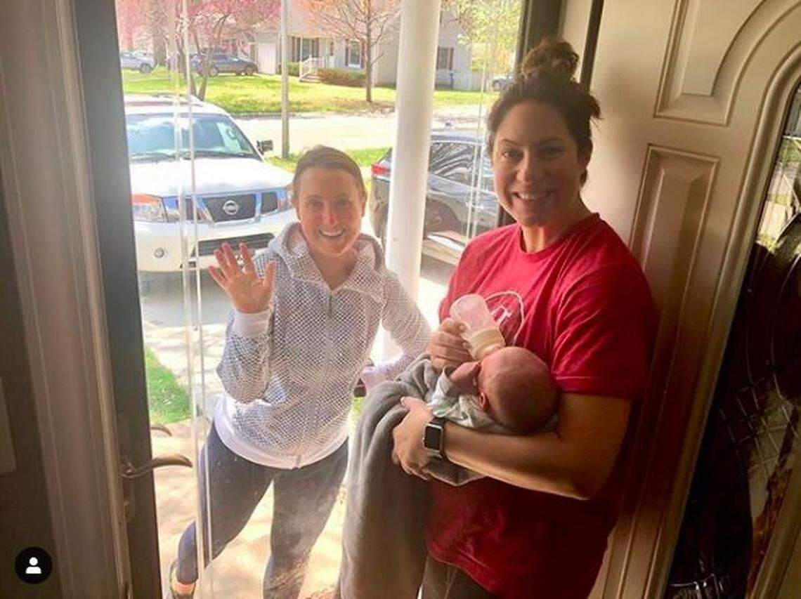New mom Christa Dunn of Prairie Village shows her new son, Jackson, to friend Cortney Edwards through the front door.