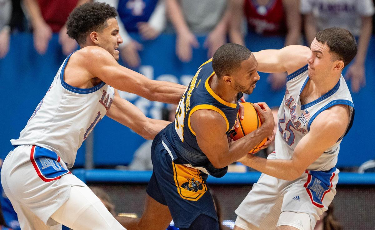 Kansas Jayhawks guard Nicolas Timberlake (25) rips the ball away from KC Roos guard Khristion Courseault (13) during an NCAA basketball game on Tuesday, Dec. 5, 2023, in Lawrence, Kan.