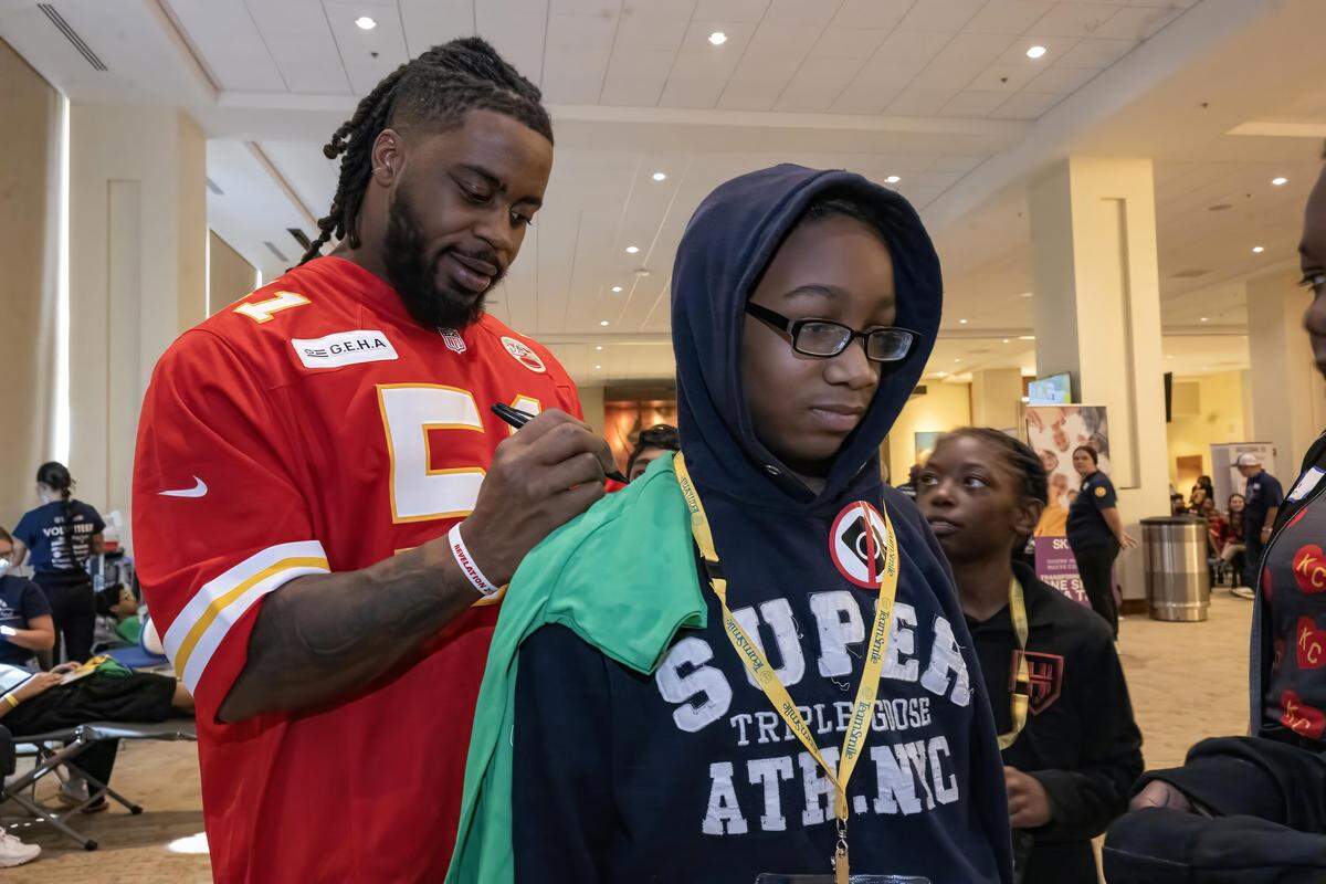 Kansas City Chiefs defensive end Mike Danna autographed a shirt for Omarian Jefferson, 11, of Kansas City, during the TeamSmile dental tailgate on Tuesday, Sept. 9, 2025 at GEHA Field at Arrowhead Stadium. More than 200 volunteer dentists, hygienists, and dental assistants, backed by TeamSmile and the Chiefs, provided free dental care to 300 children from Kansas City, Missouri, and Kansas City, Kansas schools.