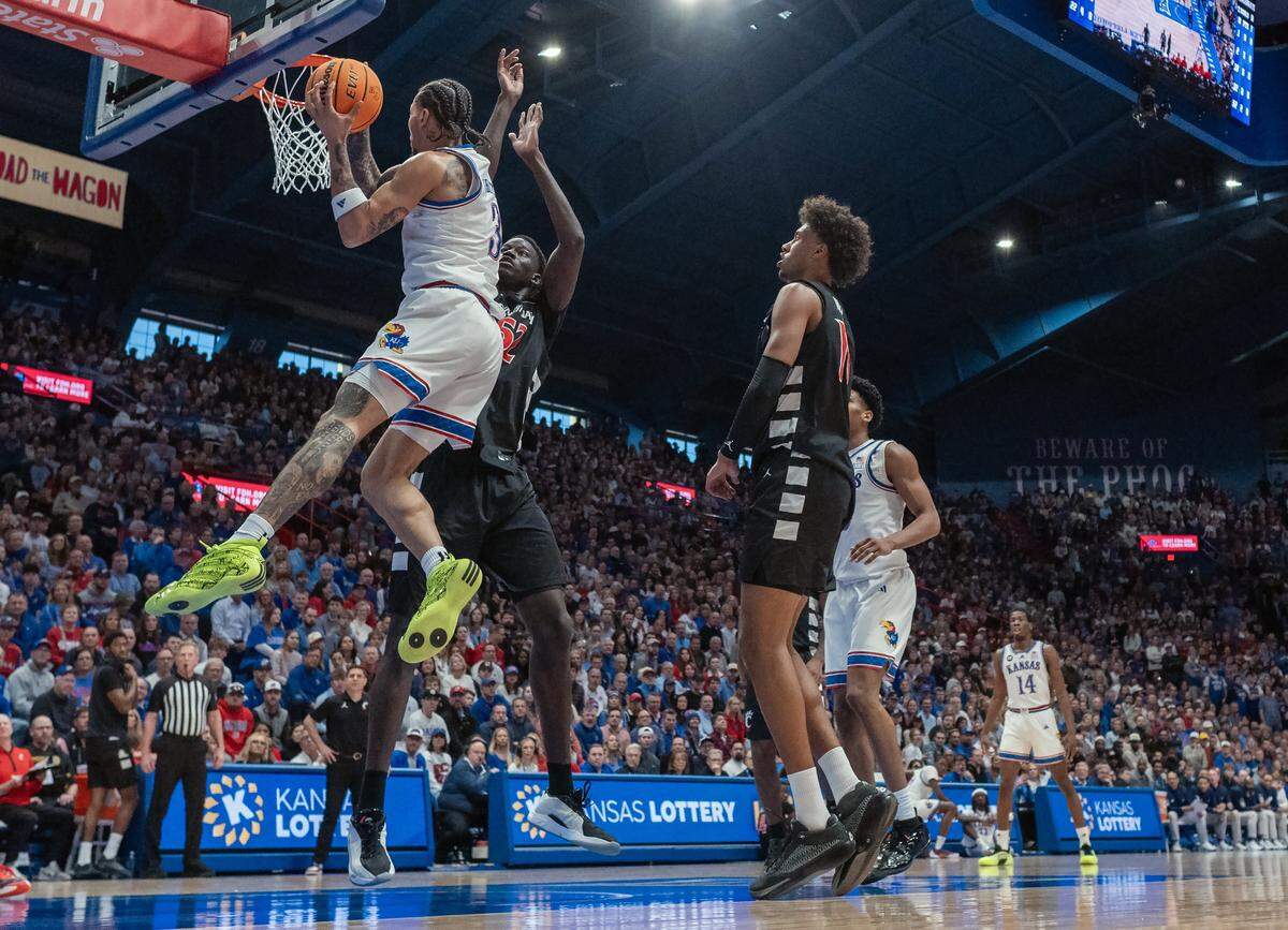 Kansas Jayhawks guard Tre White (3) goes up for a shot as Cincinnati Bearcats center Moustapha Thiam (52) defends in the first half Allen Fieldhouse on Saturday, Feb. 21, 2026, in Lawrence, Kansas.