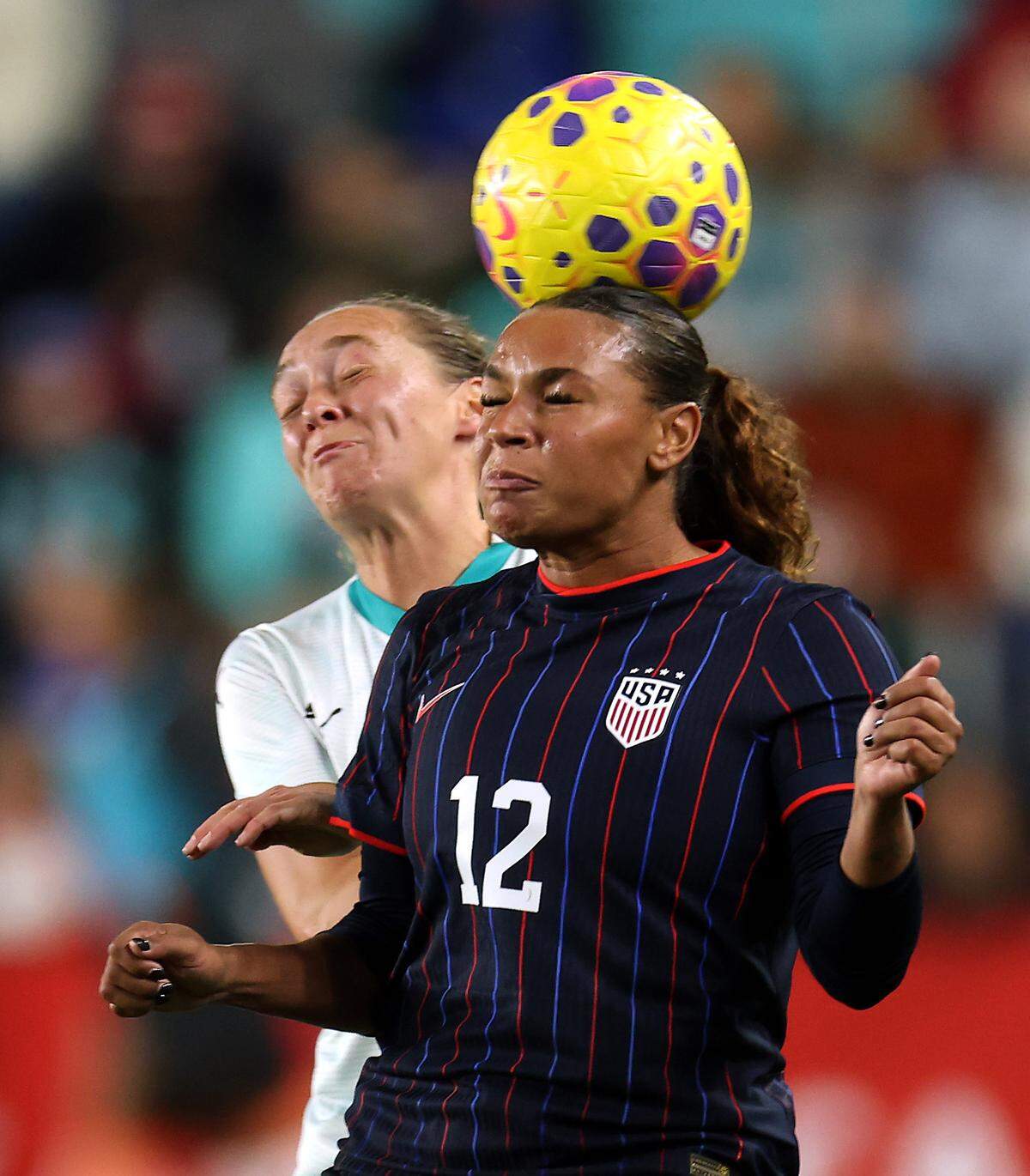 Michelle Cooper #12 of the United States battles Elizabeth Anton #19 of New Zealand for a header during the first half of the match at CPKC Stadium on October 29, 2025 in Kansas City.
