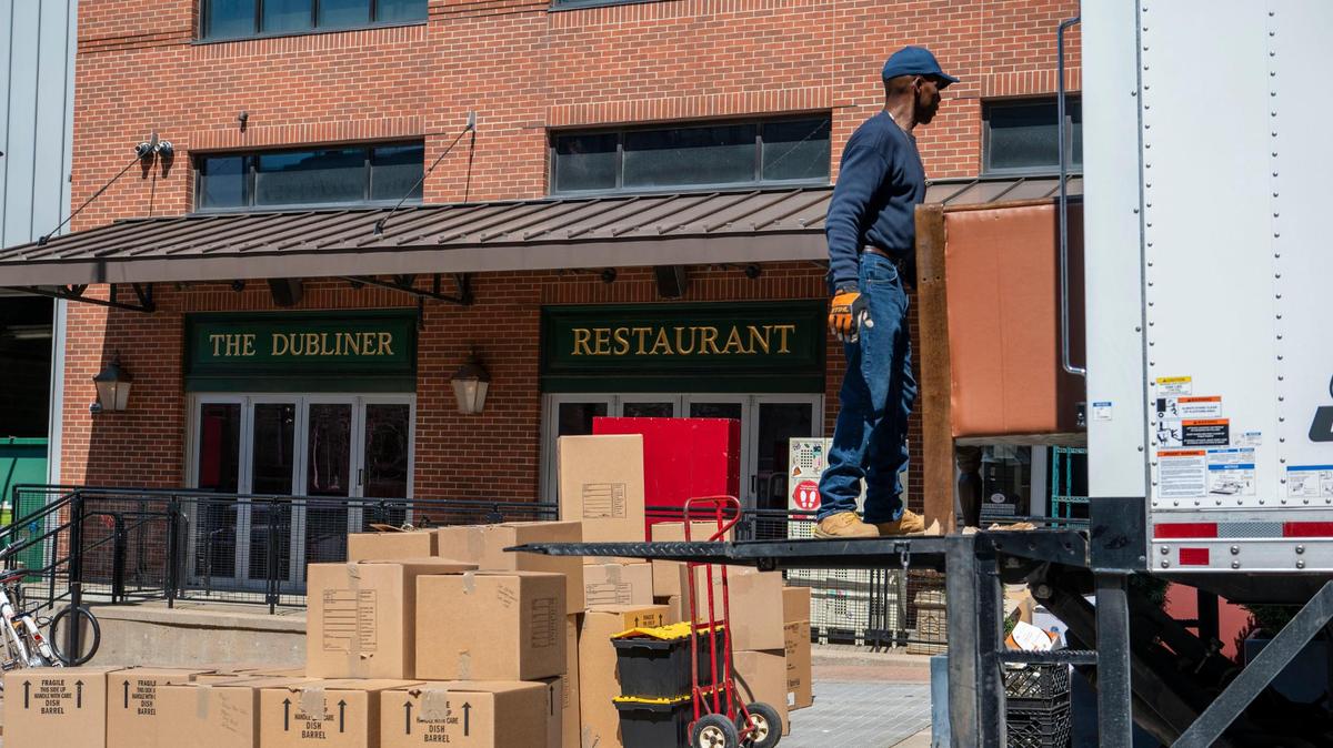 Movers haul away boxes and furniture from The Dubliner at Power & Light District on Friday.