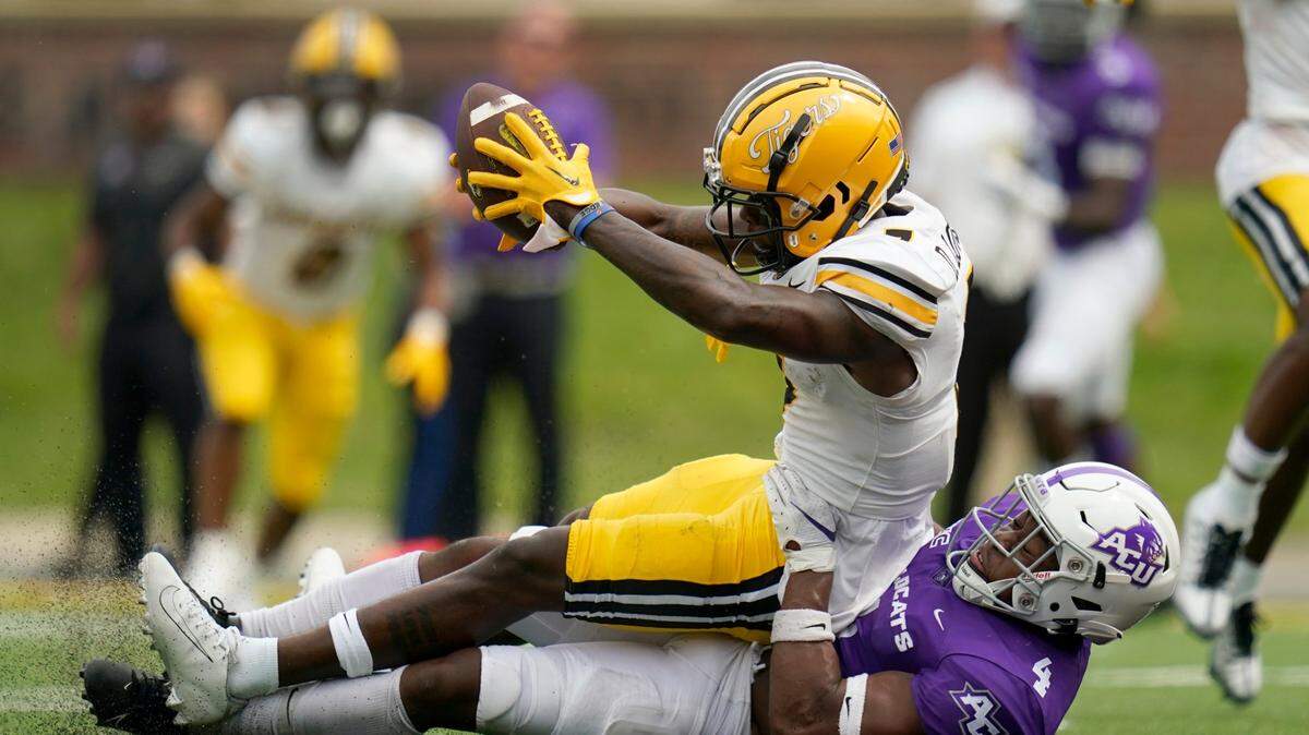 Missouri Tigers receiver Dominic Lovett, top, scores a touchdown as Abilene Christian defensive back Anthony Egbo Jr. tries to defend.