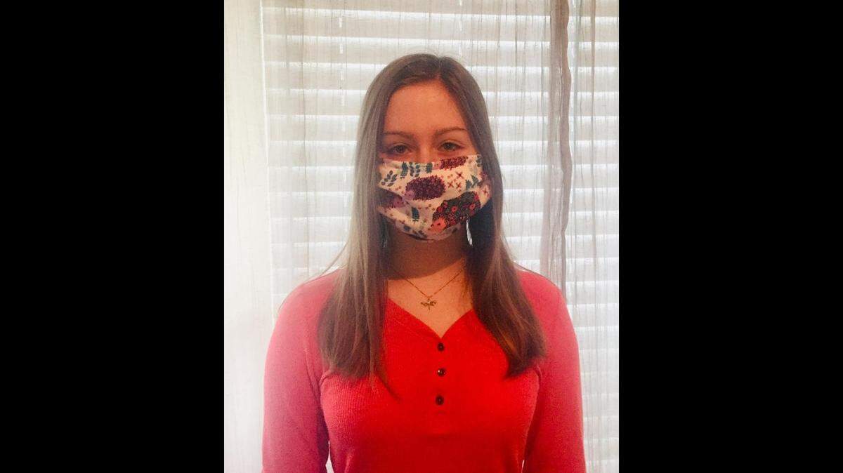 Basia Ayers of Olathe is helping her mom make surgical masks for the local medical community.