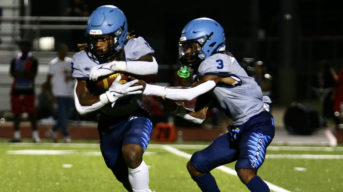 Grandview’s Mikelis Johnson takes a handoff from Ja’Lyne Armstrong during the Bulldogs’ 40-0 win over Raytown South.