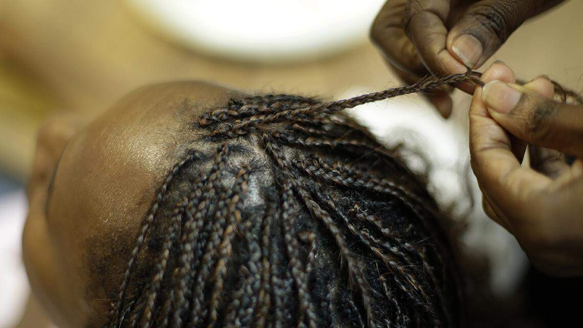 Shelly Smith braids hair for Bridget Dunmore at her salon, Braid Heaven Tuesday, Jan. 28, 2020 in Kansas City, Kansas.