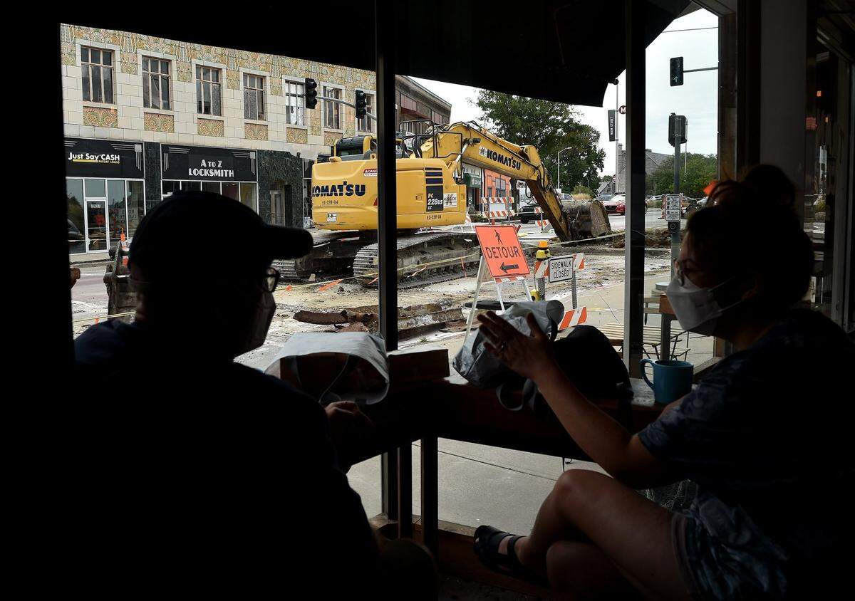 In Sept. 2021, customers sip coffee and watch construction at the now-closed Transit Coffee, at Main Street and Westport Road, which had a soft opening on Aug. 20. Operating owner Ben White said he believes that the longterm benefits of the streetcar expansion outweigh the increased taxes and short term disruption.
