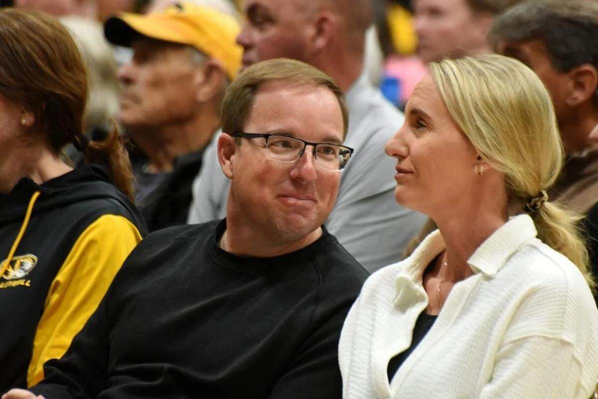 Mizzou football coach Eli Drinkwitz leans over to chat with his wife Lindsey during Kellie Harper’s introductory news conference Monday, March 31, 2025, at the Mizzou Arena practice gym. The Drinkwitzes were joined by other university leaders and Mizzou Athletics staff in support of Harper being introduced as the new MU women’s basketball coach.