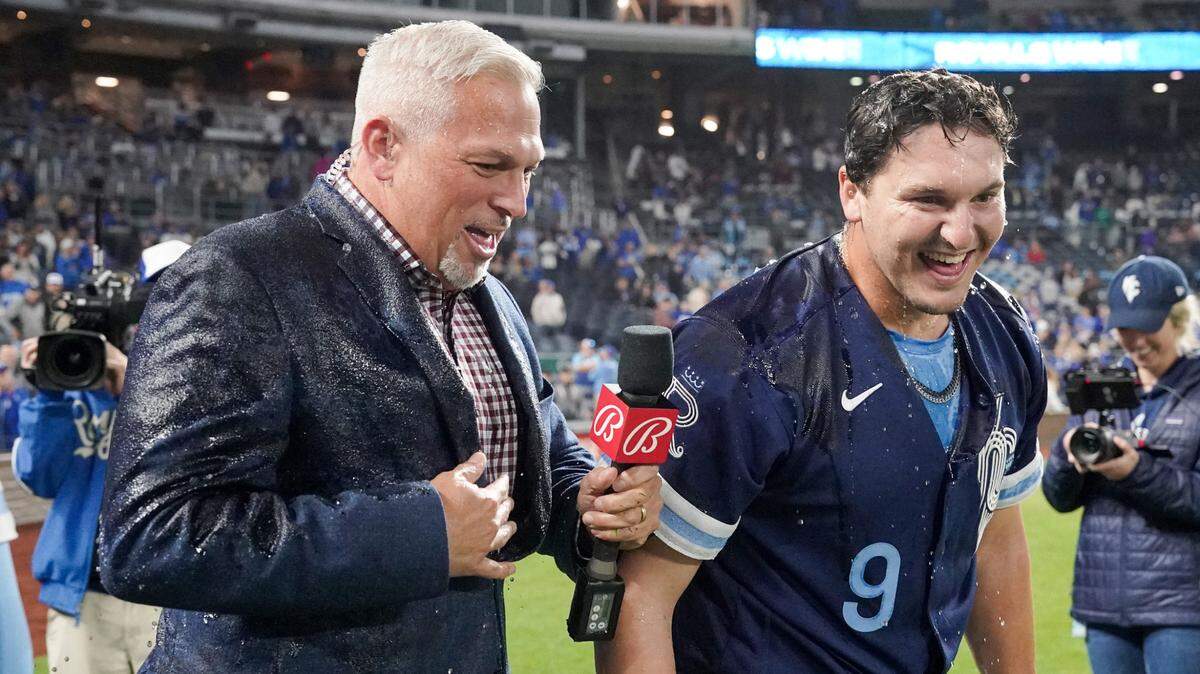 Kansas City Royals first baseman Vinnie Pasquantino (9) and Bally Sports announcer Joel Goldberg laugh after being doused by a cooler after a game against the Seattle Mariners at Kauffman Stadium on Sept. 23, 2022.