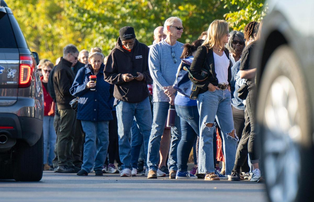 Cars streamed past as a long line of Johnson County residents gathered outside The Arts and Heritage Center in Overland Park for the first day of in-person advance voting for the 2024 General Election on Saturday, October 19, 2024.