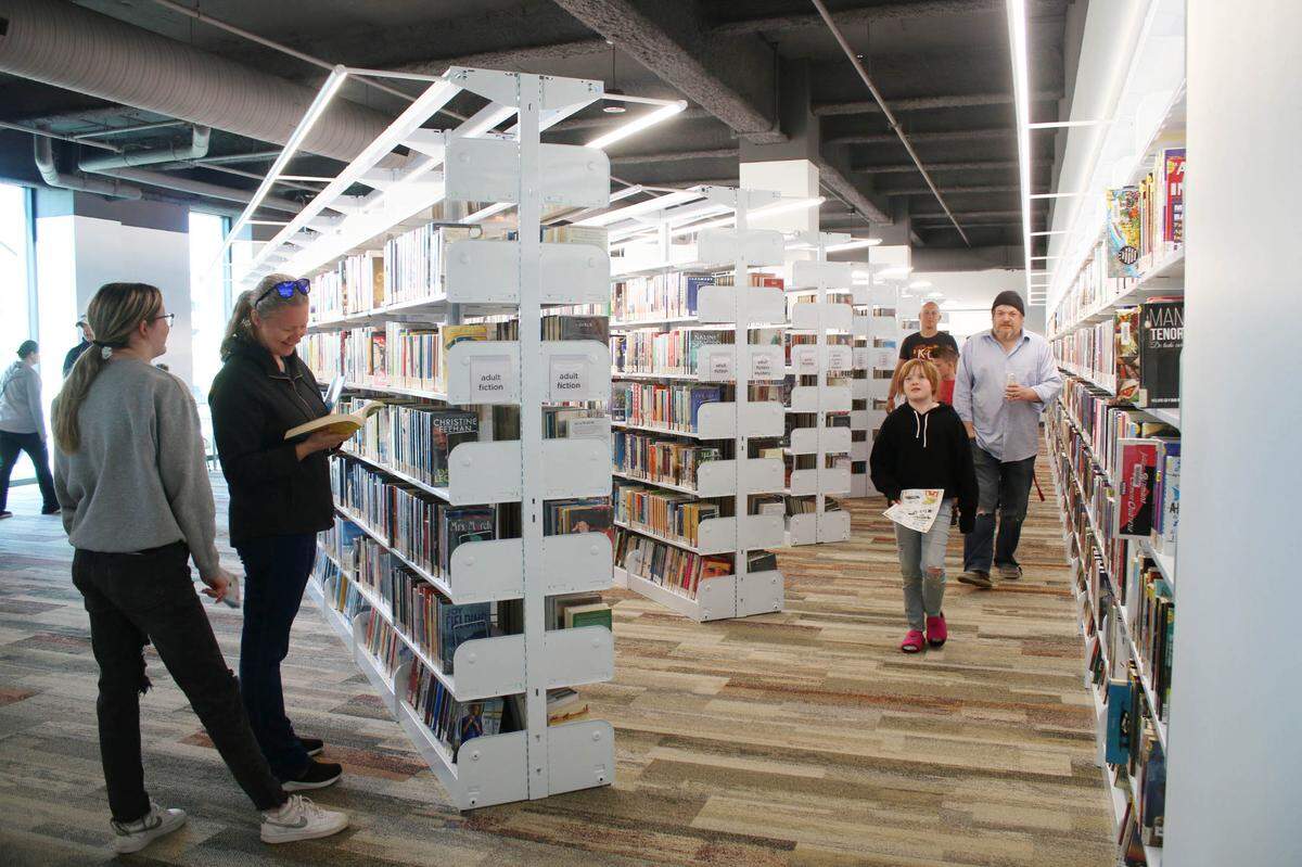 Visitors take a look at the stacks of books at Olathe’s new downtown library April 29.
