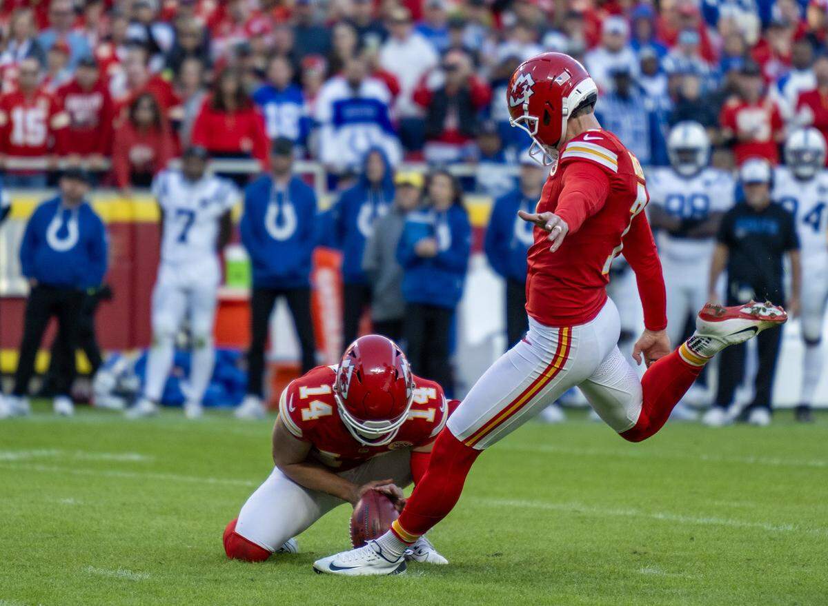 Chiefs punter Matt Araiza (No. 14) holds the ball for placekicker Harrison Butker (No. 7) on the game-winning field goal to beat the Indianapolis Colts 23-20 in overtime at GEHA Field at Arrowhead Stadium in Kansas City on Sunday, Nov. 23, 2025.