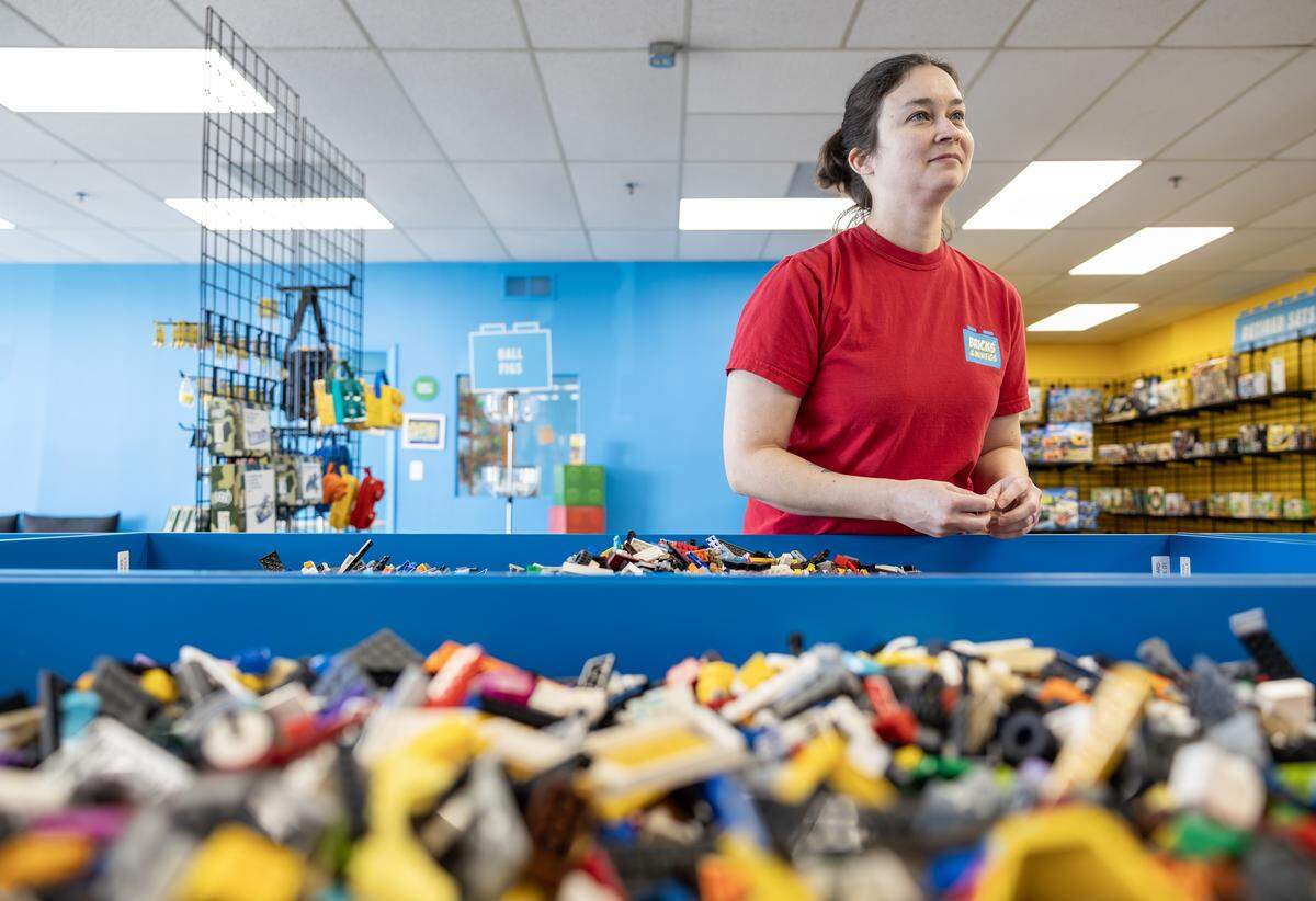 Bricks & Minifigs Lee’s Summit owner Cortney Frazon sorts through bricks in the bulk area of her new store on Thursday, Feb. 5.