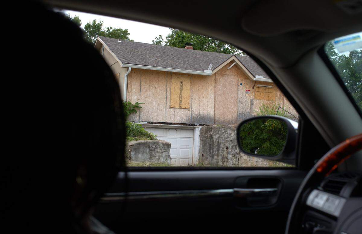 Vanessa Robinson, president of the Neighbors Who Care community group, points out a vacant home during a driving tour of northeastern Kansas City, Kansas, a struggling community beset by redlining.