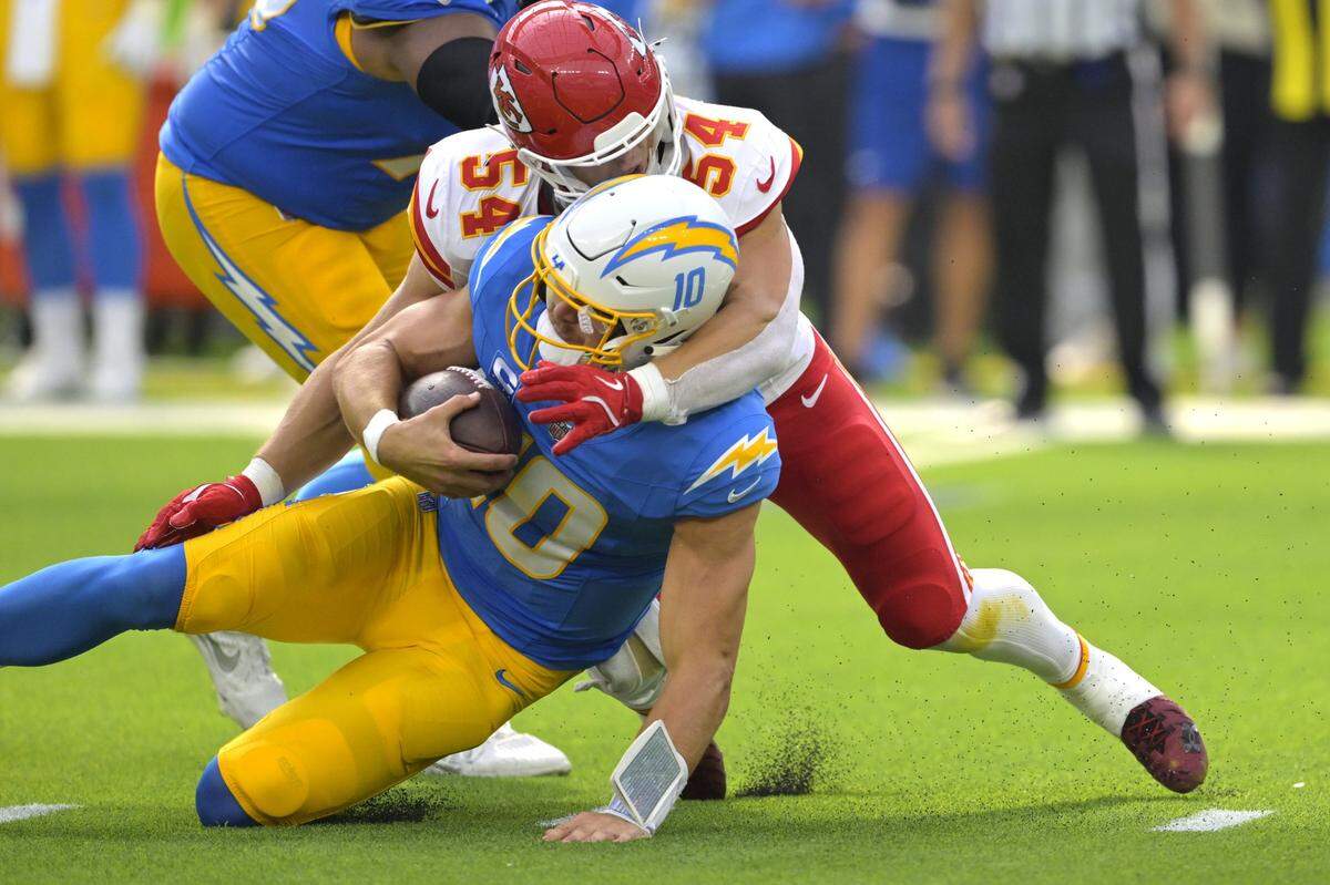 Los Angeles Chargers quarterback Justin Herbert (10) is sacked by Kansas City Chiefs linebacker Leo Chenal (54) in the first half at SoFi Stadium.