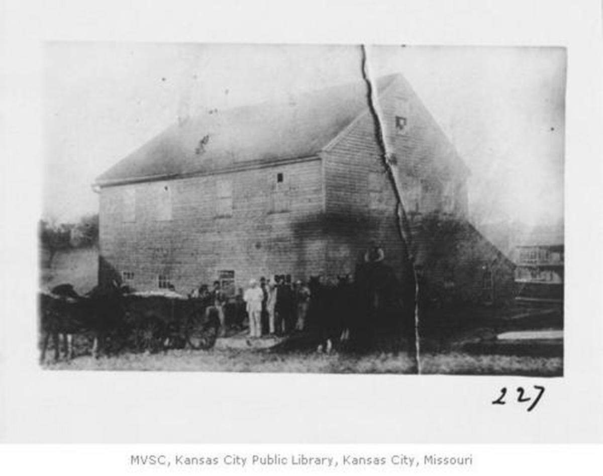 Full frontal and side view with unidentified men in foreground in 1880; located at Mill Creek Road and Westport Road.